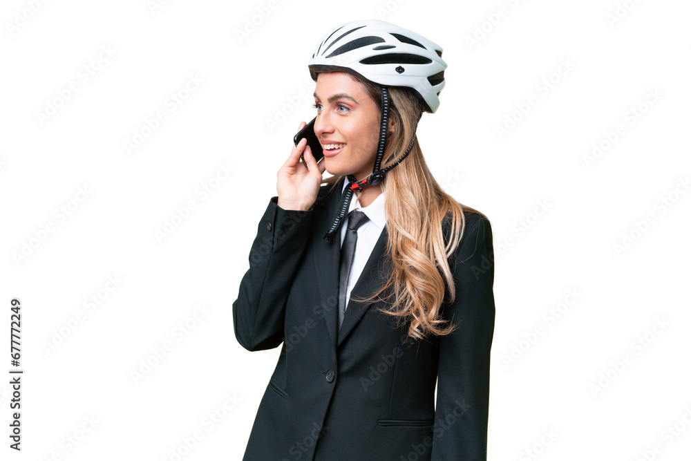 Business Uruguayan woman wearing a helmet biker over isolated background keeping a conversation with the mobile phone with someone Business Uruguayan woman wearing a helmet biker over isolated background keeping a conversation with the mobile phone with someone