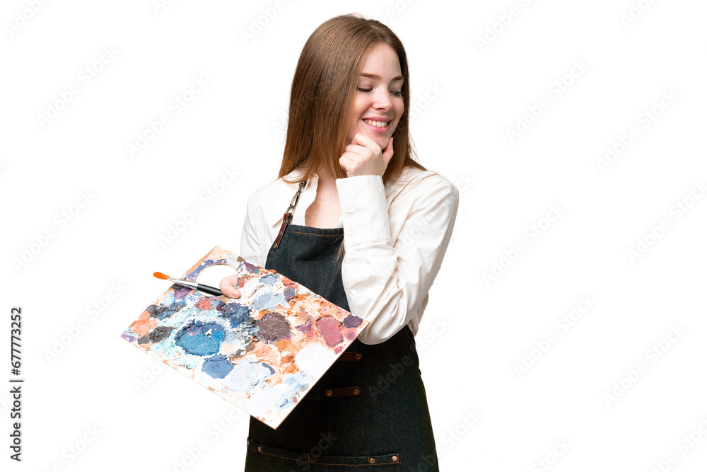Young artist woman holding a palette over isolated chroma key background looking to the side and smiling Young artist woman holding a palette over isolated chroma key background looking to the side and smiling