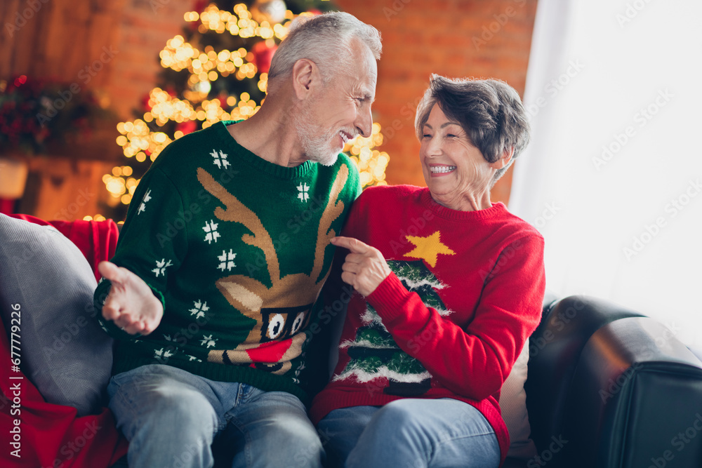 Photo banner photo of old funny couple retired people wear funny ugly new year sweaters laughing joke sitting favorite comfortable sofa indoors
