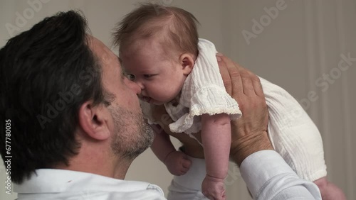 Happy father lifts up his newborn baby and rejoices