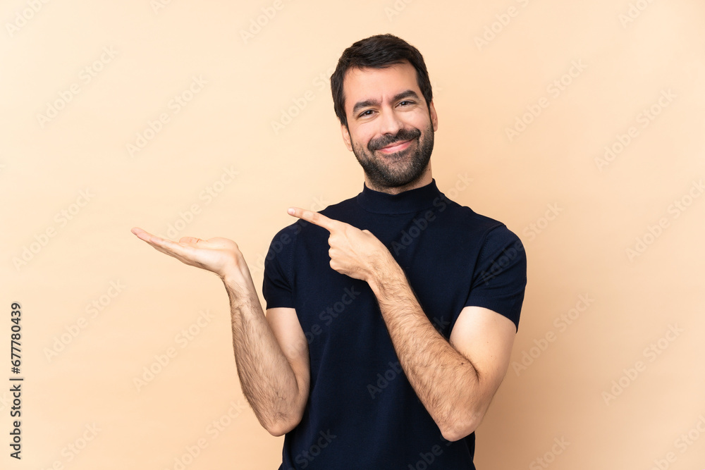 Caucasian handsome man over isolated background holding copyspace imaginary on the palm to insert an ad Caucasian handsome man over isolated background holding copyspace imaginary on the palm to insert an ad