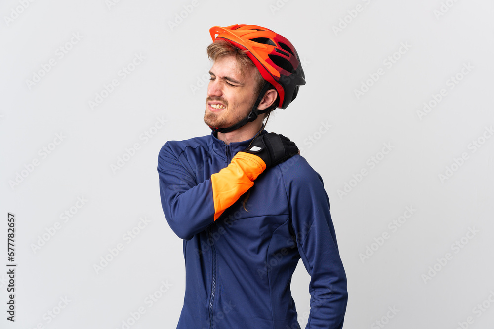 Young cyclist blonde man isolated on white background suffering from pain in shoulder for having made an effort - obrazy, fototapety, plakaty 