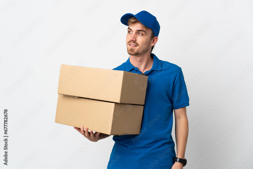 Young delivery blonde man isolated on white background looking to the side and smiling Young delivery blonde man isolated on white background looking to the side and smiling