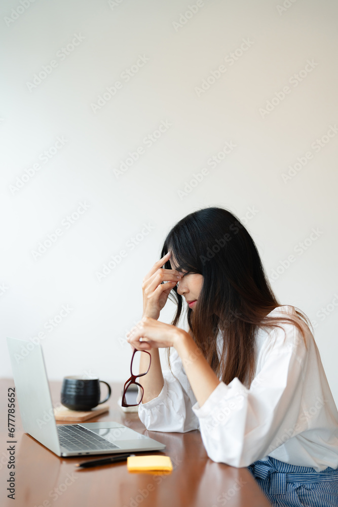 Writer woman headache with stress while thinking creative idea and writing business content in cafe Writer woman headache with stress while thinking creative idea and writing business content in cafe