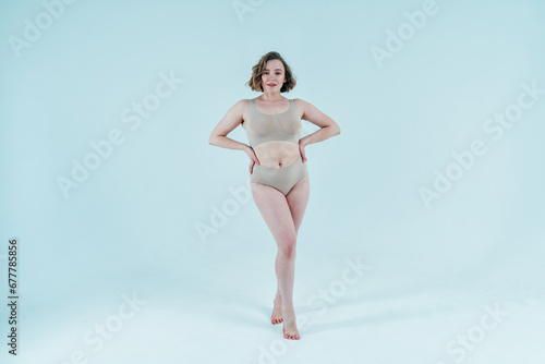 Image of a beautiful woman posing in studio wearing lingerie. Concept about body positivity and self acceptance