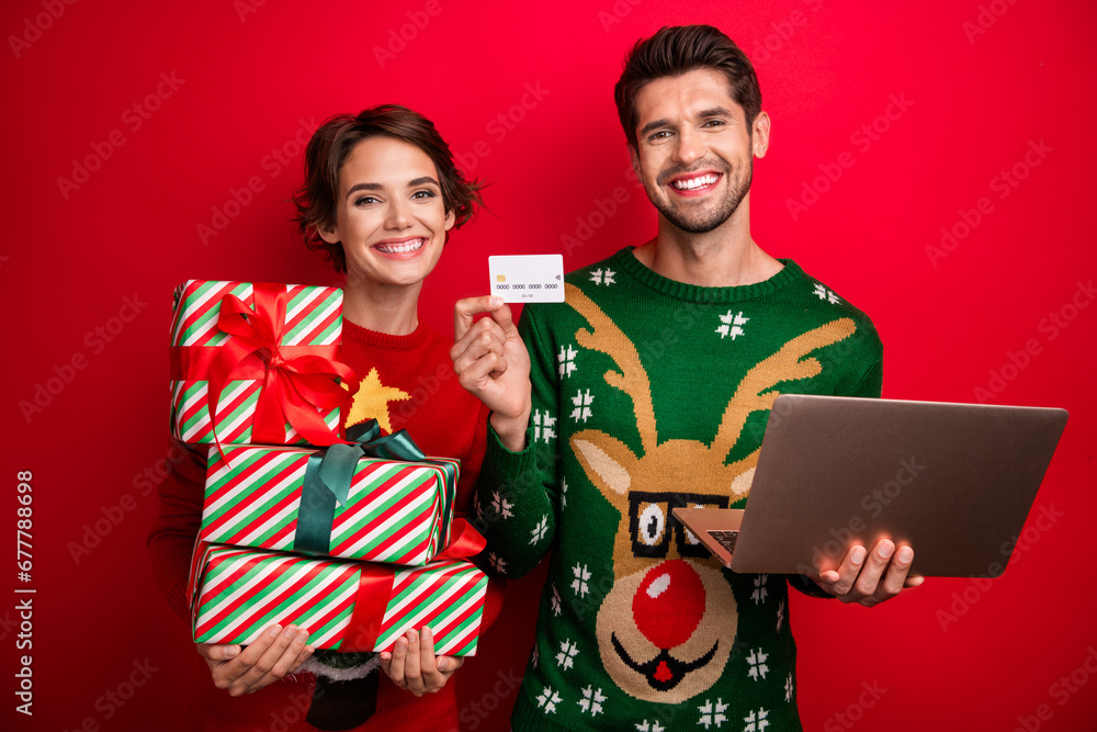 Photo of family friends lady guy using netbook with gift package purchase with debit card for new year party isolated bright color background Photo of family friends lady guy using netbook with gift package purchase with debit card for new year party isolated bright color background
