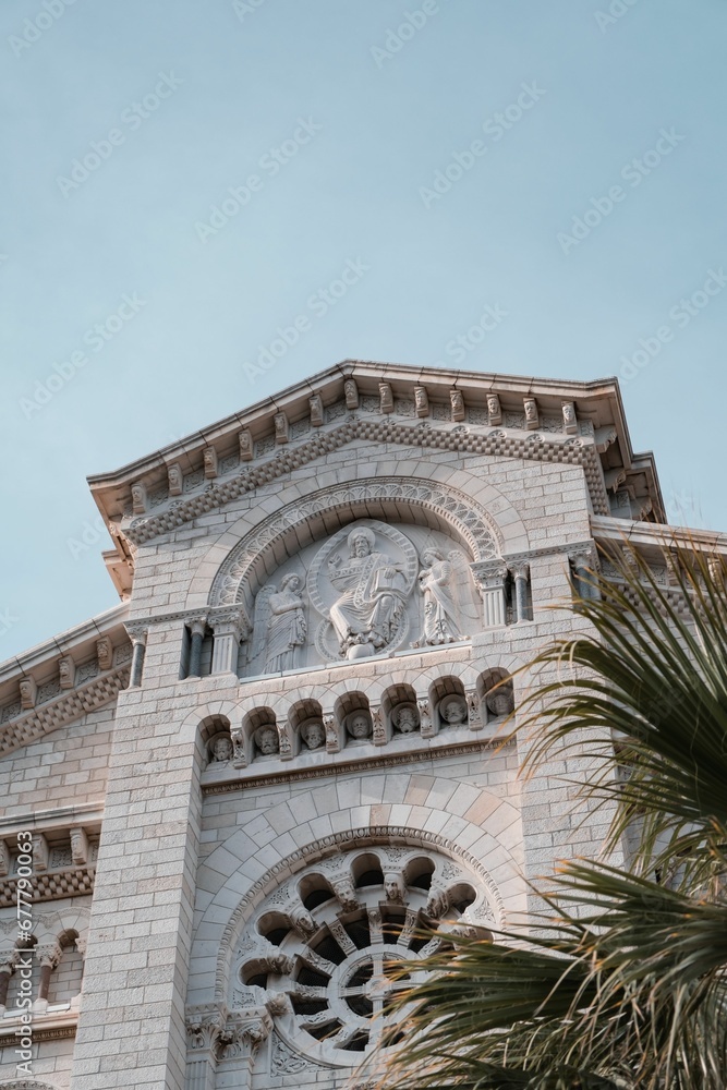 Low angle shot of Saint Nicholas Cathedral in Monaco behind a palm tree