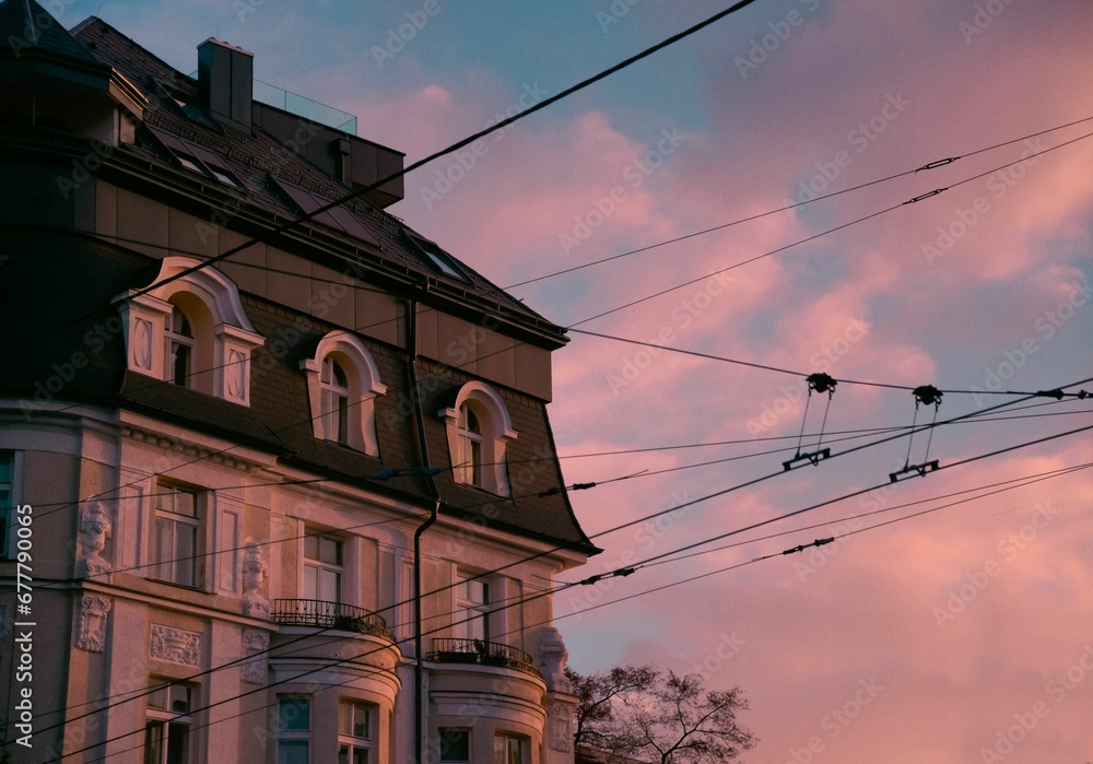 Beautiful shot of an old building seen behind electricity wires at pink sunset Beautiful shot of an old building seen behind electricity wires at pink sunset