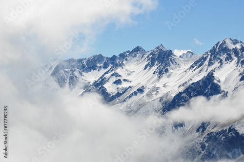 Bird's eye view of rough mountains covered in snow in smoggy weather © Wirestock