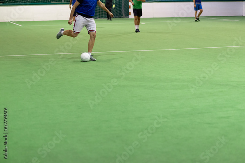 Players in action on five a side match. Sport concept. Indoors hall with artificial turf.