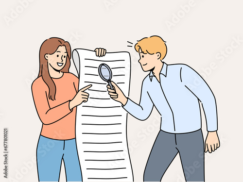 Man and woman are studying large business document using magnifying glass to look for hidden information in legal documents. Business people analyze and check data before signing contract