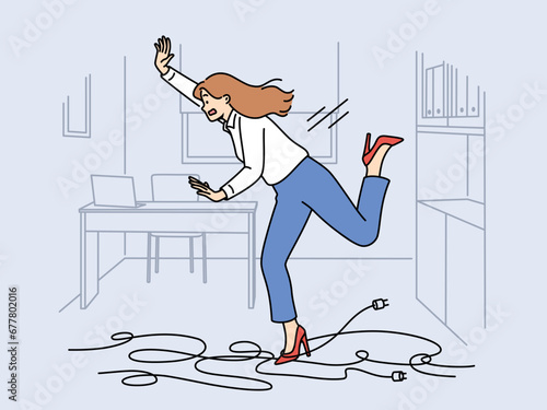 Businesswoman trips on wires and falls, risking injury due to clumsiness or mess in workplace. Falling girl office employee gets tangled in electrical cable lying on floor and screams falling photo