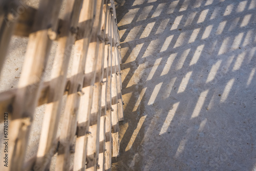 The wooden frame of an Asian yurt casts a shadow on the ground
