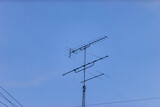 a television antenna against a clear blue sky,
