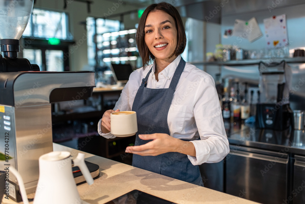 Cute coffee shop assistant holding a coffee cup Cute coffee shop assistant holding a coffee cup