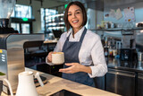 Cute coffee shop assistant holding a coffee cup