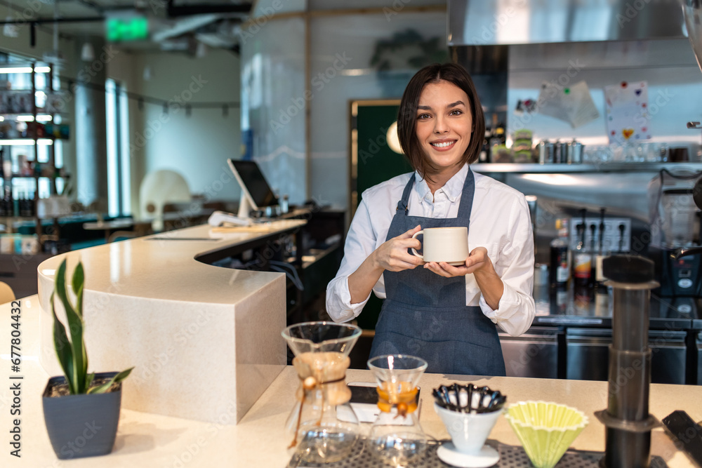 Cute coffee shop assistant holding a coffee cup