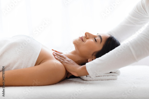 Beautiful young indian woman receiving relaxing shoulder massage