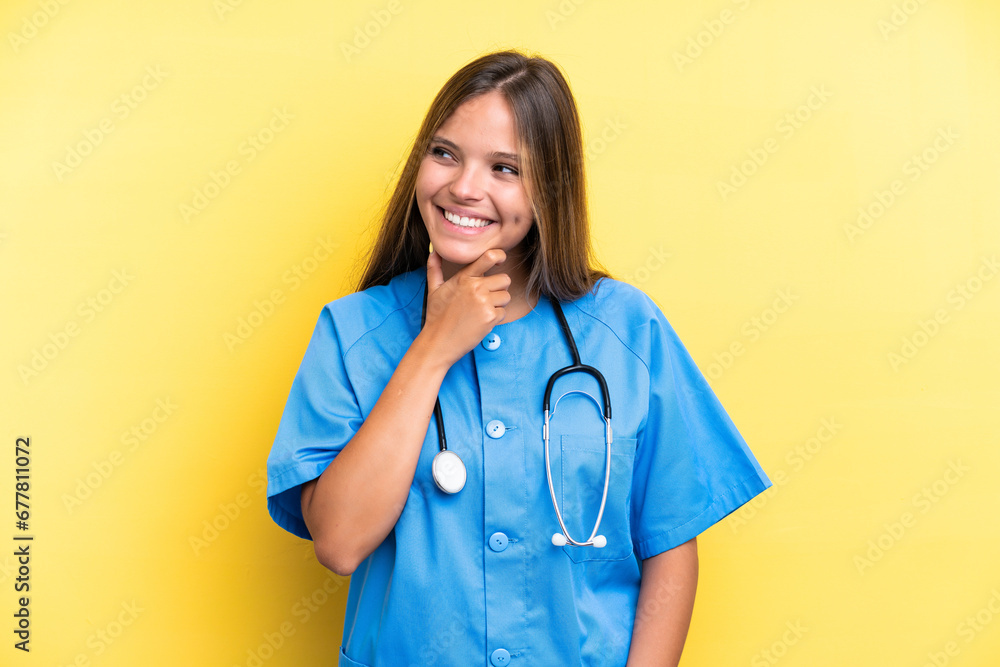 Young nurse caucasian woman isolated on yellow background looking to the side and smiling Young nurse caucasian woman isolated on yellow background looking to the side and smiling