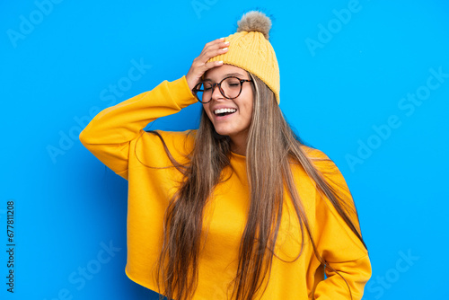 Young caucasian woman wearing winter clothes isolated on blue background smiling a lot