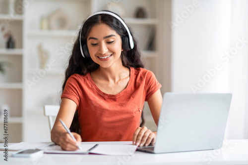 Cheerful young indian woman student studying online