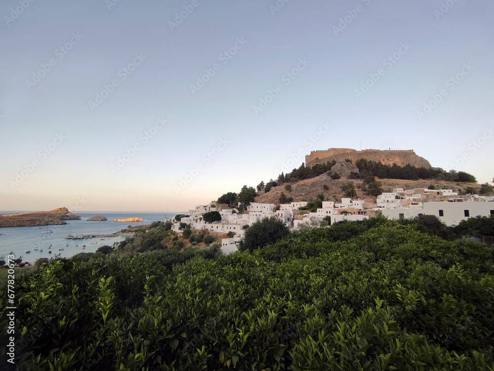 Village of Lindos with the ancient acropolis on the hilltop and the bay with the islets below. Dodecanese, Rhodes island, Greece.