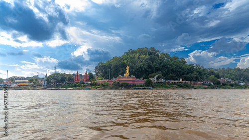 Golden Triangle the 3 borders of Thailand Laos and Myanmar lovely Golden Buddha on the Mekong River with boats in the river and mountains in the background  photo