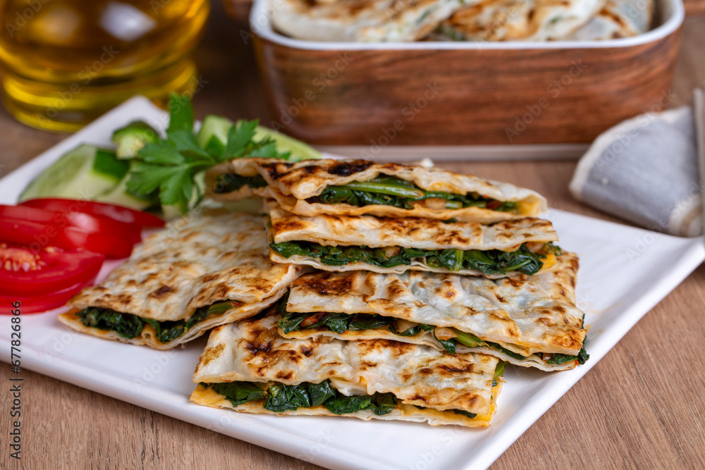 Turkish pancake gozleme with cheese and herb. The appetizer is Turkish pastry. There are varieties such as cheese, spinach, potato Turkish pancake gozleme with cheese and herb. The appetizer is Turkish pastry. There are varieties such as cheese, spinach, potato