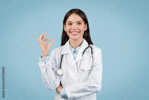 Happy young female doctor showing OK sign with hand