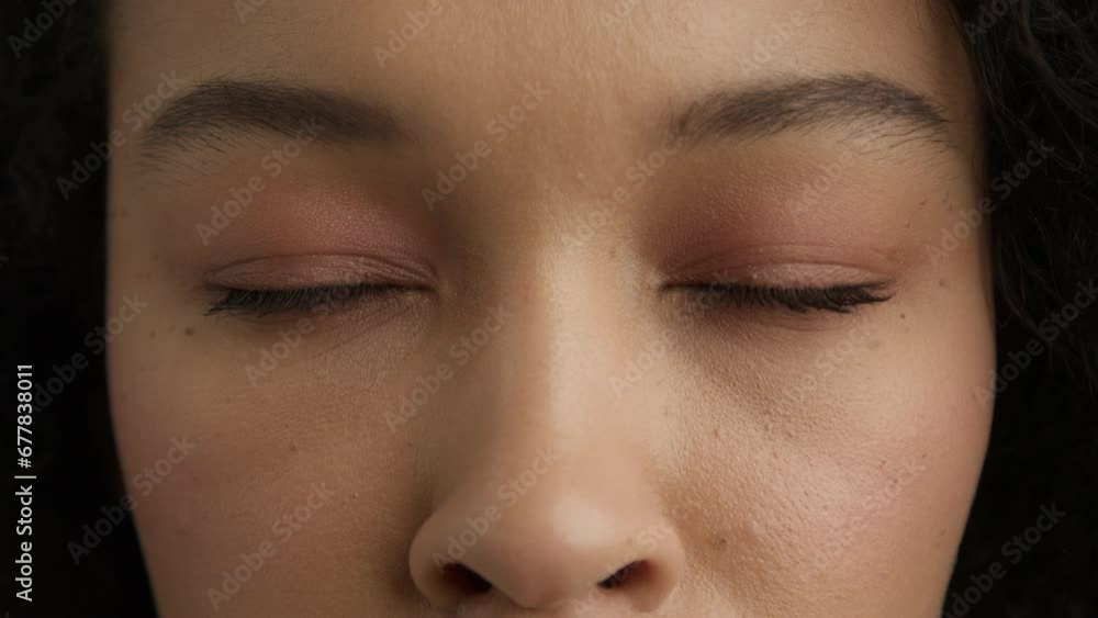 Attractive brunette girl opening beautiful brown eyes. Natural Beauty with healthy skin. Woman with multi ethnical eye shape in slow motion. Close up of calm sad mixed race female face with dark skin Attractive brunette girl opening beautiful brown eyes. Natural Beauty with healthy skin. Woman with multi ethnical eye shape in slow motion. Close up of calm sad mixed race female face with dark skin