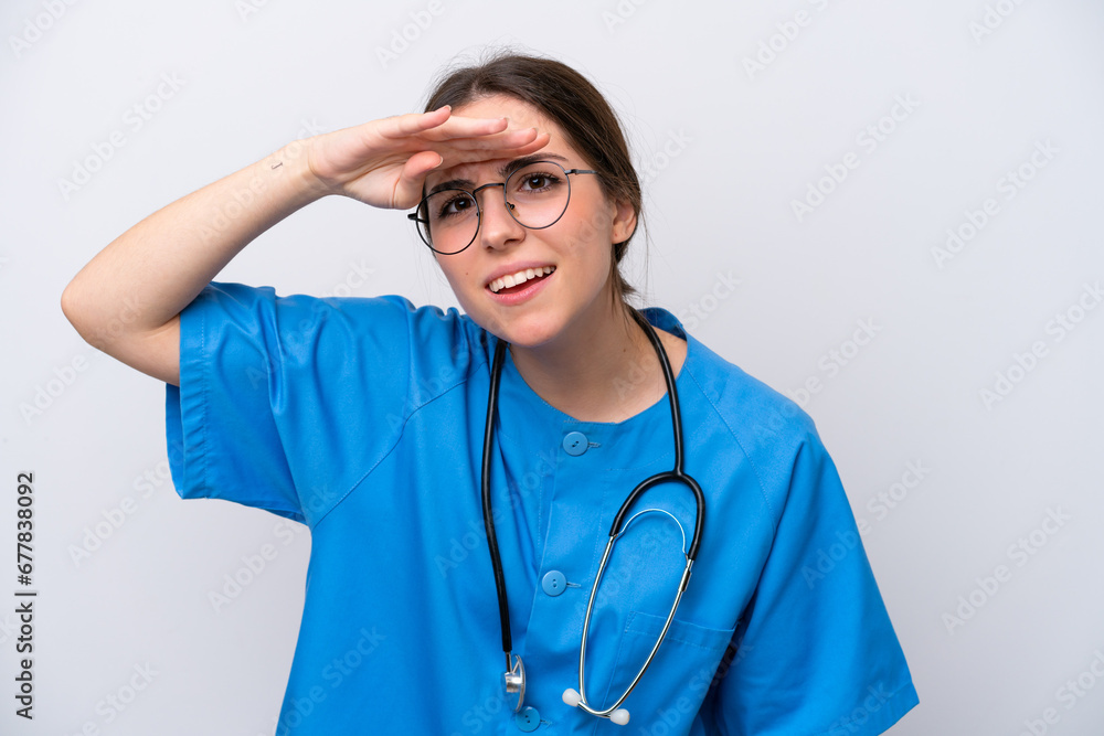surgeon doctor woman holding tools isolated on white background looking far away with hand to look something surgeon doctor woman holding tools isolated on white background looking far away with hand to look something