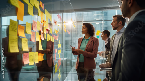 A professional team engaged in a brainstorming session, using colorful sticky notes on a glass wall to organize their ideas and strategies.