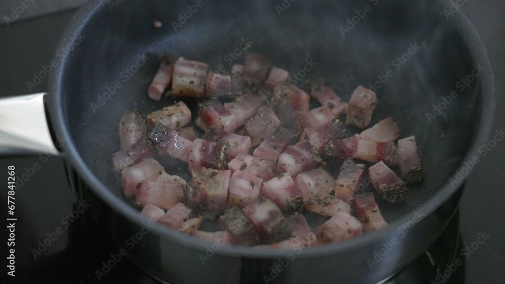 Cooking pieces of bacon inside pan, close-up greasy food preparation for morning breakfast routine Cooking pieces of bacon inside pan, close-up greasy food preparation for morning breakfast routine