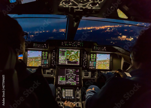 View from the cockpit of a modern airplane landing at an illuminated vilage at night