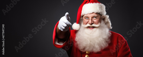 Portrait of the Santa Claus pointing his finger and smile for the camera .