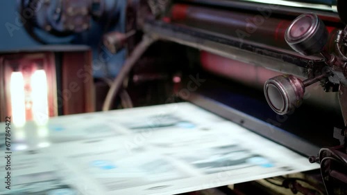 Fleyers and leaflets being printed in a printing house factory photo