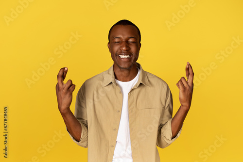 Cheerful handsome calm millennial european guy crossed fingers gesture, make a wish with closed eyes
