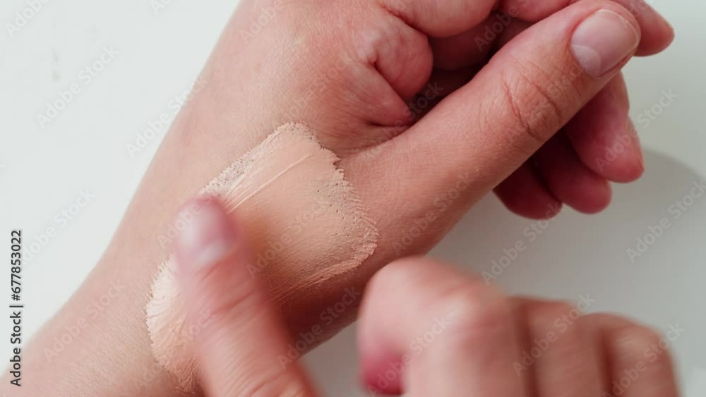 Beauty blender on woman hand. Mixing or applying foundation tone. Professional tools for makeup, cosmetics products concept. Make-up liquid beige foundation Beauty blender on woman hand. Mixing or applying foundation tone. Professional tools for makeup, cosmetics products concept. Make-up liquid beige foundation