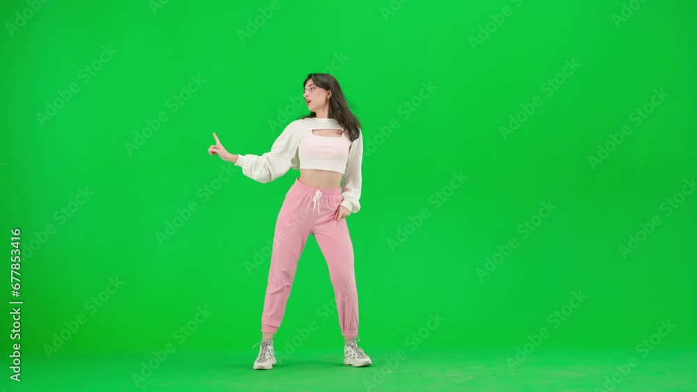 Appealing woman in white top dancing jazz funk choreography on chroma key green screen background in a studio. Appealing woman in white top dancing jazz funk choreography on chroma key green screen background in a studio.
