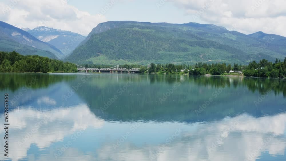 Serene Mountain Lake with Reflection and Bridge in Distance Serene Mountain Lake with Reflection and Bridge in Distance