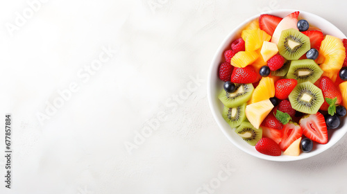 Healthy detox fruits salad in bowl on light surface, with empty copy space