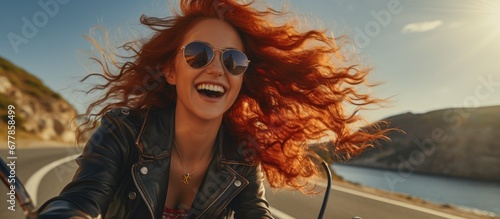 The red haired woman smiled happily as she rode her motorcycle against the wind with a retro fashion style against a scenic background a perfect blend of business and travel defining her uni