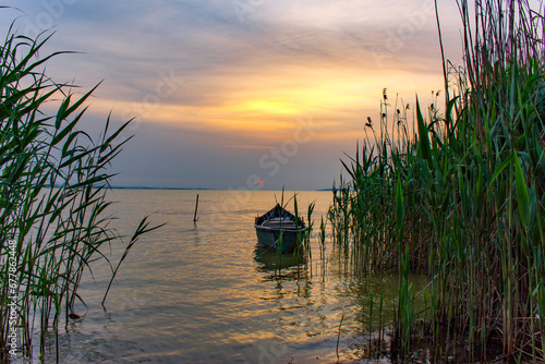 boat and reeds at sunrise on the lake