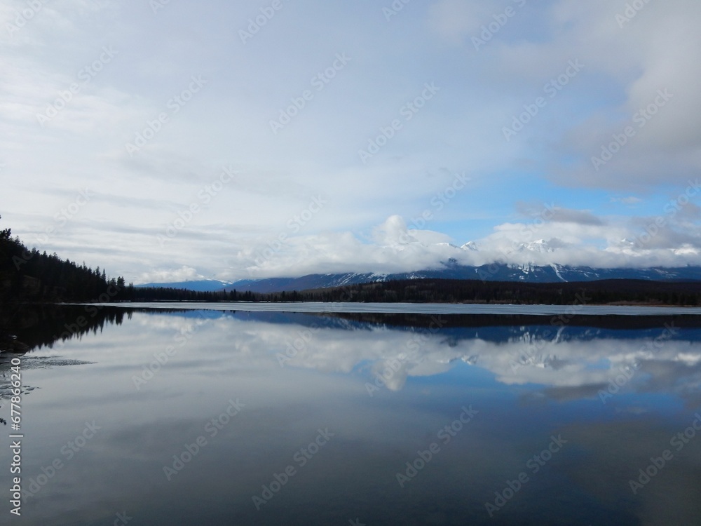 Beautiful view of snowy hills symmetrically reflecting on the lake water