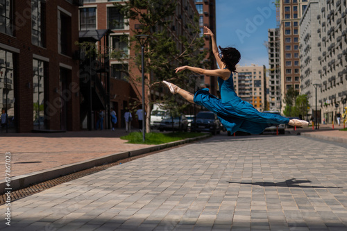 Beautiful Asian ballerina dancing outdoors. Urban landscape. Grand jete.  © Михаил Решетников