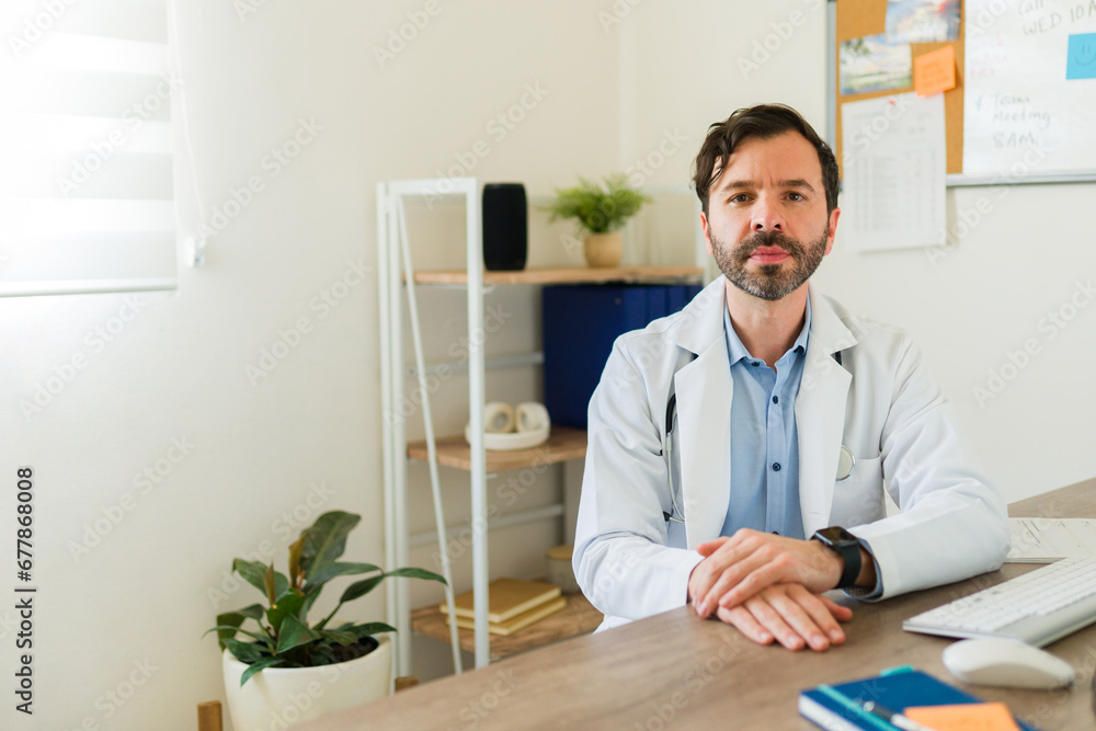 Fototapeta premium Hispanic doctor working at his office with a lab coat