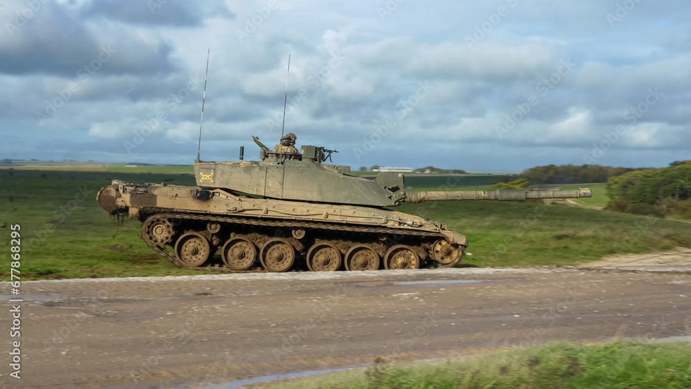 close-up of Commander and gunner directing a British army FV4034 Challenger 2 ii main battle tank moving across a grass field at speed, on a military exercise, Wiltshire UK close-up of Commander and gunner directing a British army FV4034 Challenger 2 ii main battle tank moving across a grass field at speed, on a military exercise, Wiltshire UK