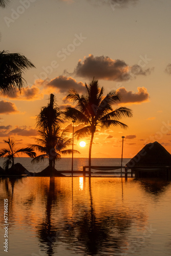 Sunrise over the Gulf of Mexico reflected into the infinity pool at the resort photo