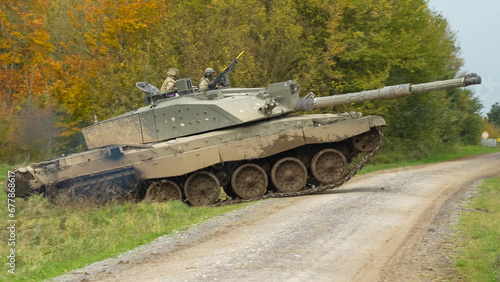 close-up of Commander and gunner directing a British army FV4034 Challenger 2 ii main battle tank as it rises to cross over a dirt track, on a military exercise, Wiltshire UK