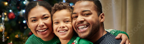 portrait of jolly african american family in cozy sweaters smiling at camera, Christmas, banner